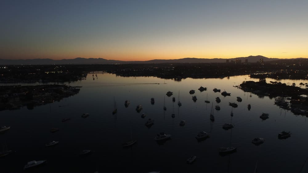 Newport Harbour at sunrise, seen from the air, with moored boats and the Balboa Peninsula beyond
